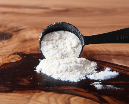 spoonful of caramel flavored popcorn seasoning on wood kitchen counter