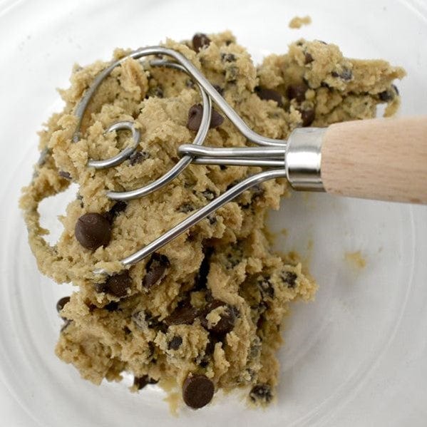 closeup of Norpro 12'' Danish Dough Whisk stainless steel wire coil mixing cookie dough inside clear glass mixing bowl